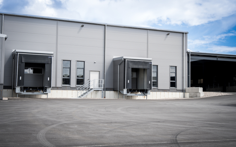 Die neue Logistikhalle mit zwei Verladerampen und einer Au&szlig;entreppe