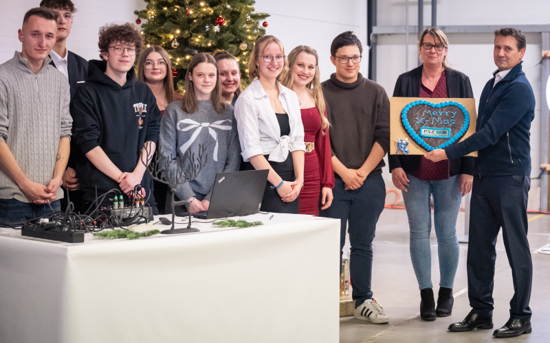 Die Auszubildenden &uuml;berreichen Herrn Steinbacher ein Lebkuchenherz mit der Aufschrift &bdquo;Merry X-Mas&ldquo;