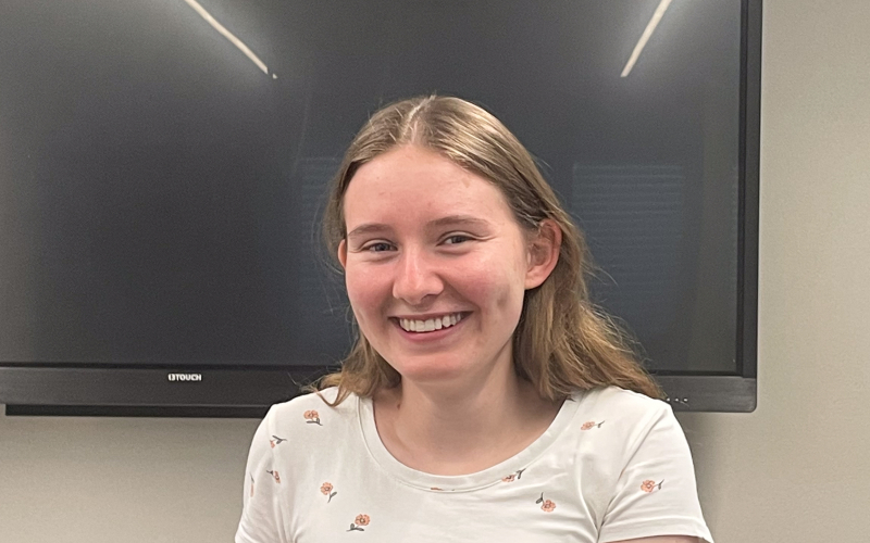 Anja M&uuml;ller, Sachbearbeiterin HR, l&auml;chelnd an einem Tisch