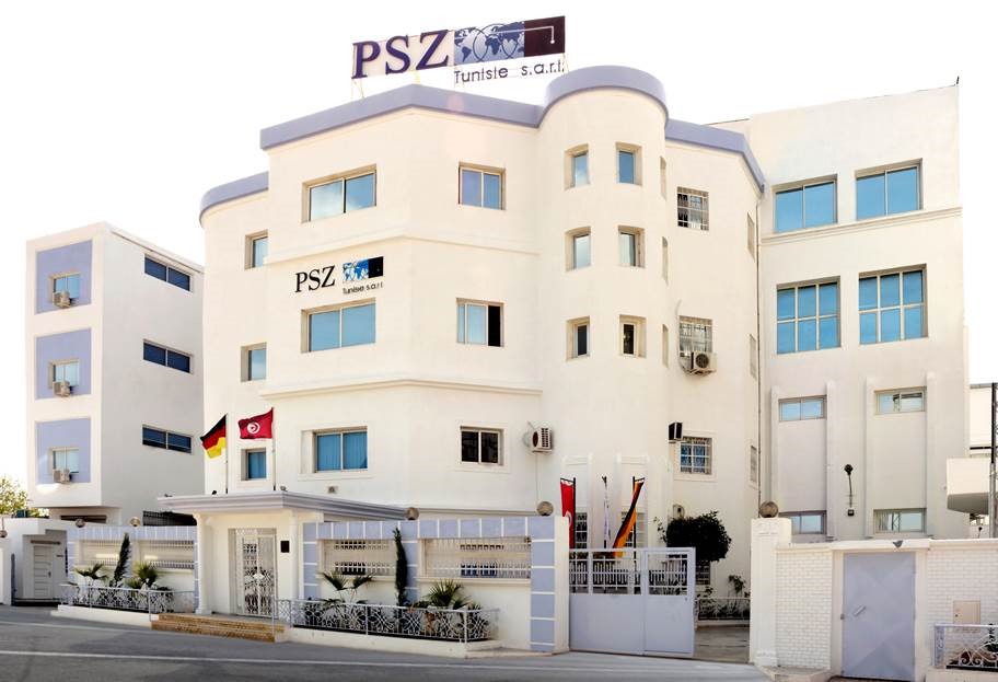Weißes Gebäude der PSZ Tunisie in Ksar Hellal mit deutscher und tunesischer Flagge